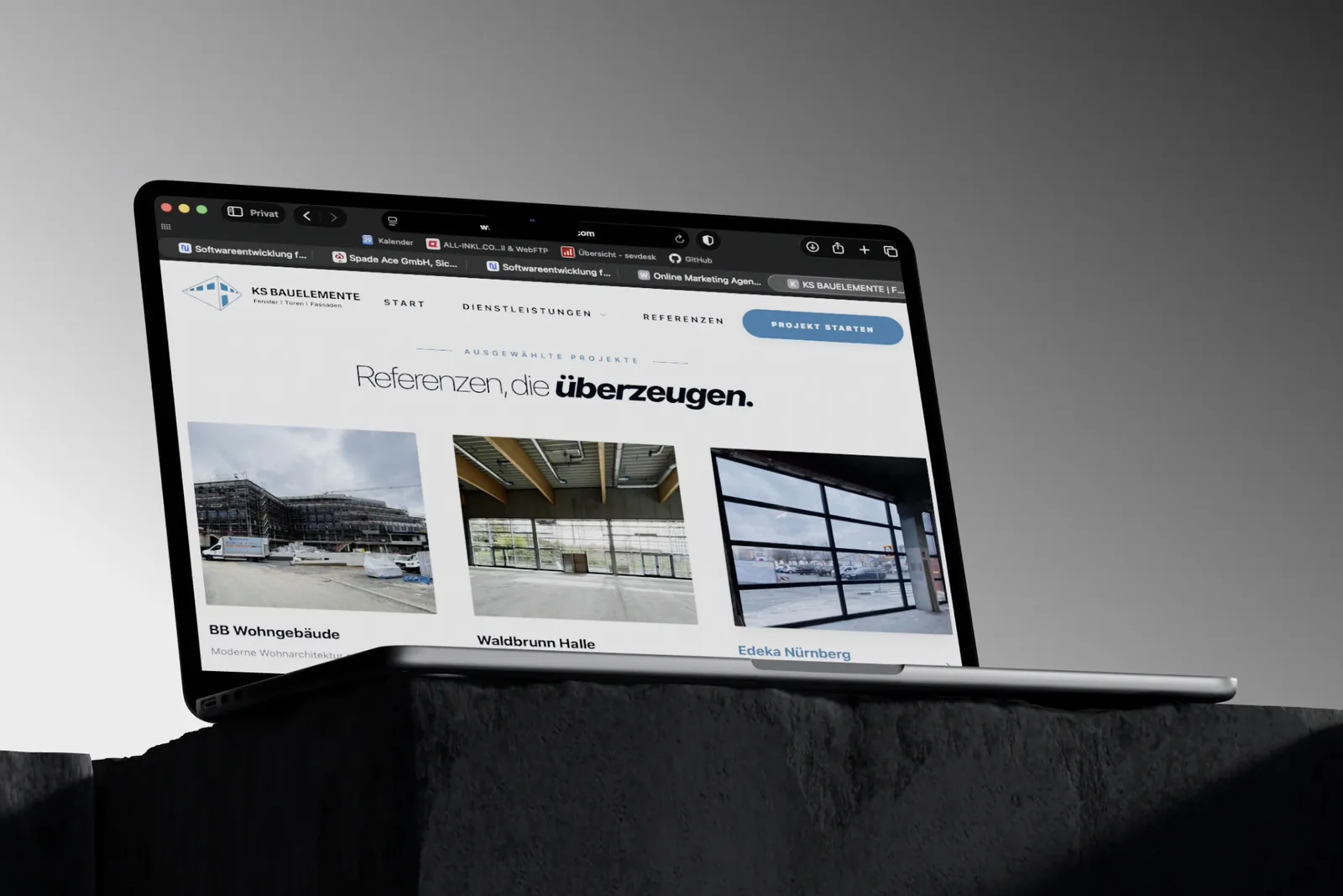 Die Website von KS Bauelemente auf einem Notebook: der Abschnitt „Referenzen, die überzeugen“ mit drei Objektfotos — Wohngebäude, Halle und eine Glasfassade.