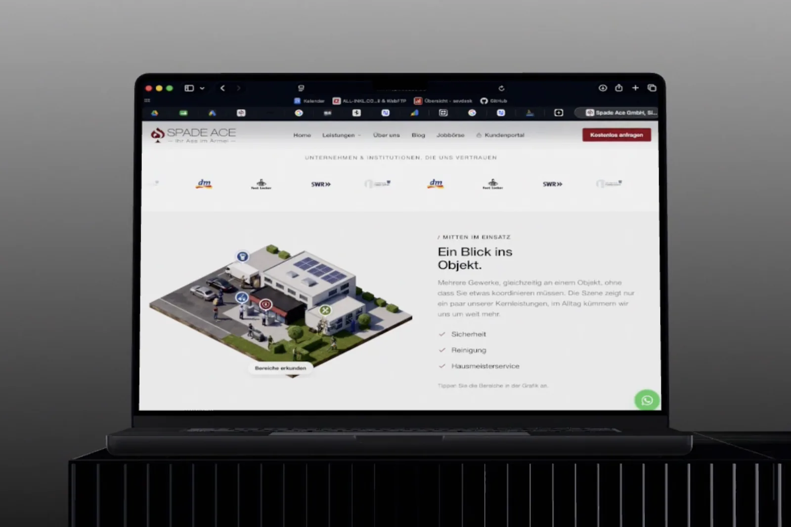 Die Website von Spade Ace auf einem Notebook: eine isometrische Grafik eines Firmengeländes mit anklickbaren Bereichen, daneben die Leistungen Sicherheit, Reinigung und Hausmeisterservice.